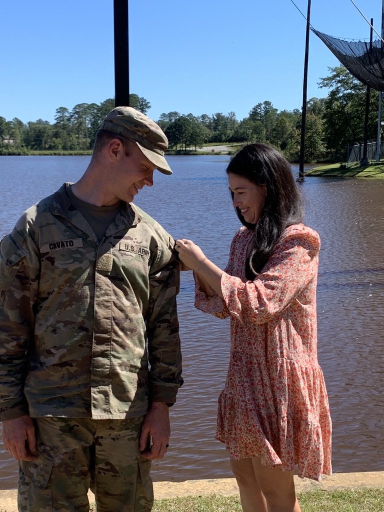 Nick Cavato in U.S. Army uniform while his wife pins his rank at a promotion ceremony.